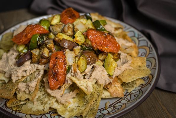 Roasted Veggie and Hummus Vegan Nachos are a quickly prepared and delicious alternative to traditional nachos! 2geekswhoeat.com #vegan #recipe