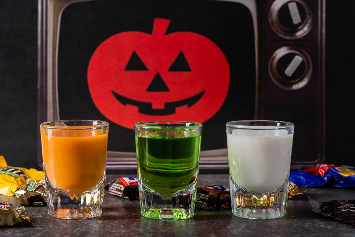 To get ready for Joe Bob's Halloween Hootenanny on Shudder, The Geeks interviewed Darcy the Mail Girl and made a series of shots, Silver Shamrock Shots, inspired by one of her favorite movies! 2geekswhoeat.com #JoeBobBriggs #Shudder #HorrorRecipes #HalloweenRecipes #HorrorMovieRecipes #SilverShamrock #Shots #ShotRecipes